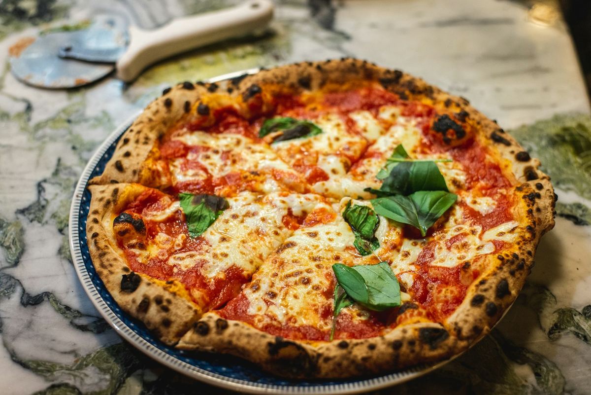 Pizza margherita con bordo alto e basilico, vista dall'alto